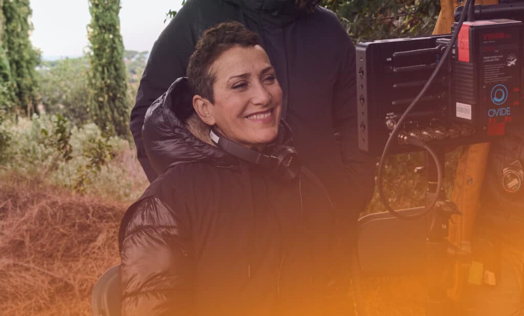 Laura Mañá rient darrera la càmera amb ponxo de pluja
